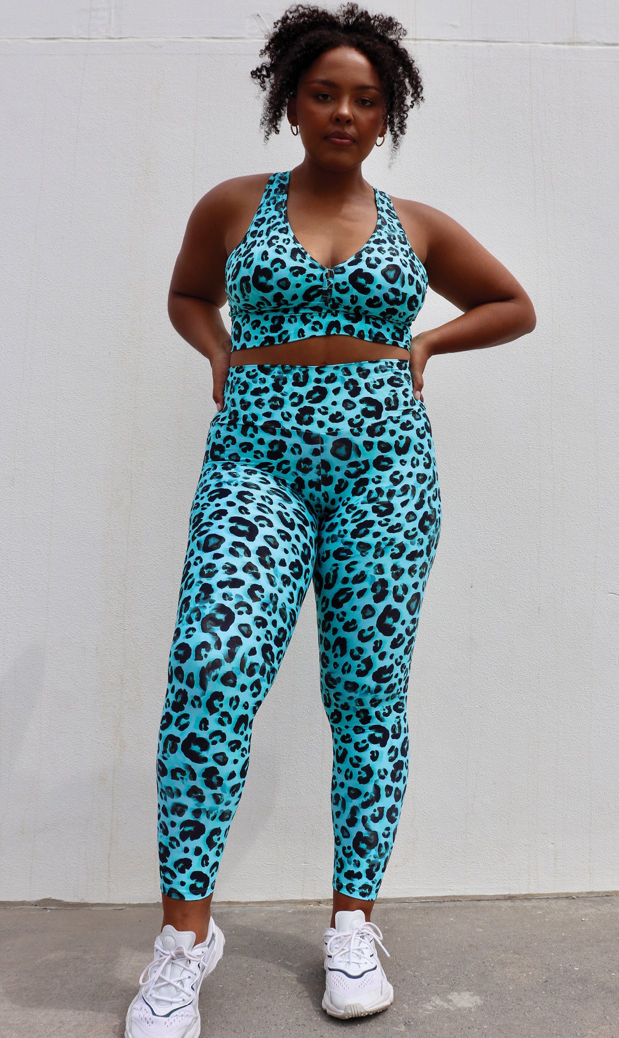 Lady wearing black and aqua leopard print ultra high waist scrunch bum leggings & matching racer back bra