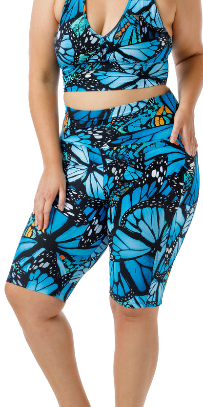 Front view of girl in blue animal print JH Butterfly Biker Shorts with Pockets putting one hand in the pocket
