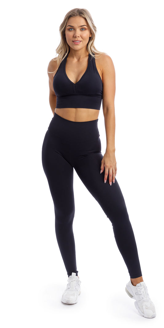 Girl wearing midnight body luxe ultra high waist leggings & matching racer bra