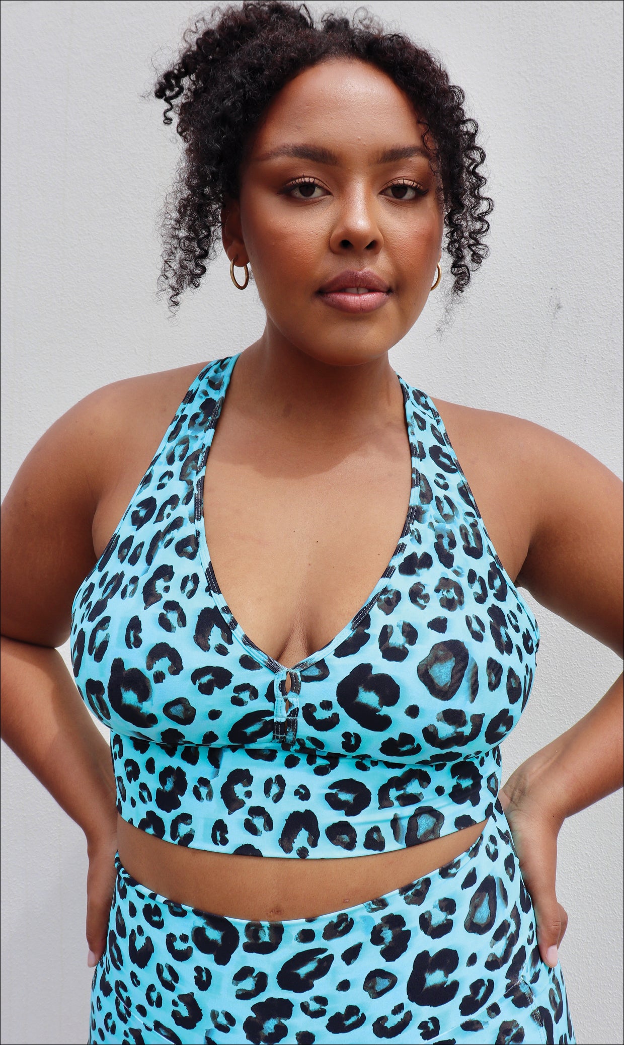 Lady in black and aqua leopard print racer back bra & matching midi shorts with pockets