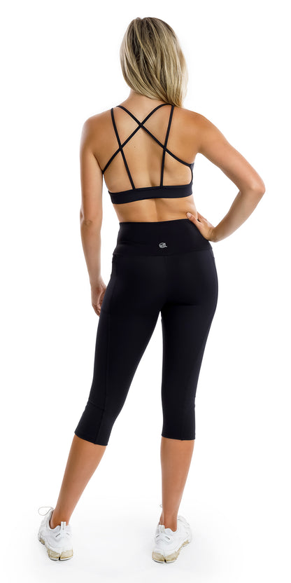 Full body rear view of girl in black Midnight Eco Diamond Back Bra and matching bottoms putting one hand on waist