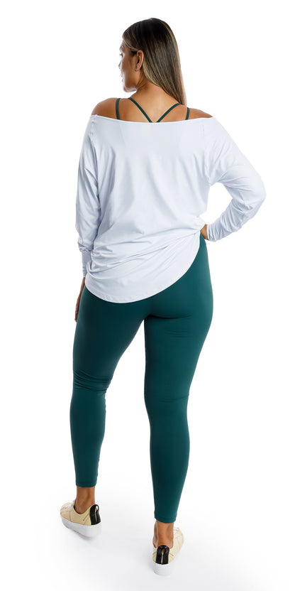 Full body back view of lady in White Off The Shoulder Long Sleeve Tee and teal coloured leggings putting left foot forward and right hand on waist