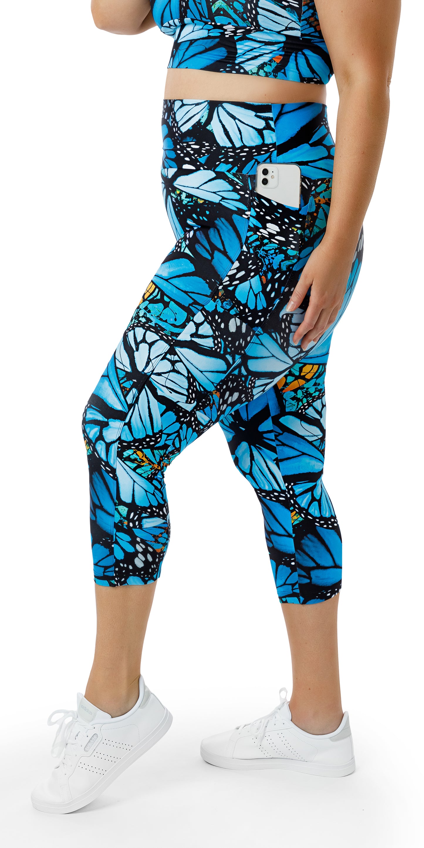 Side view of girl in blue animal print JH Butterfly Eco Capri Leggings with Pockets showing a phone in the pocket
