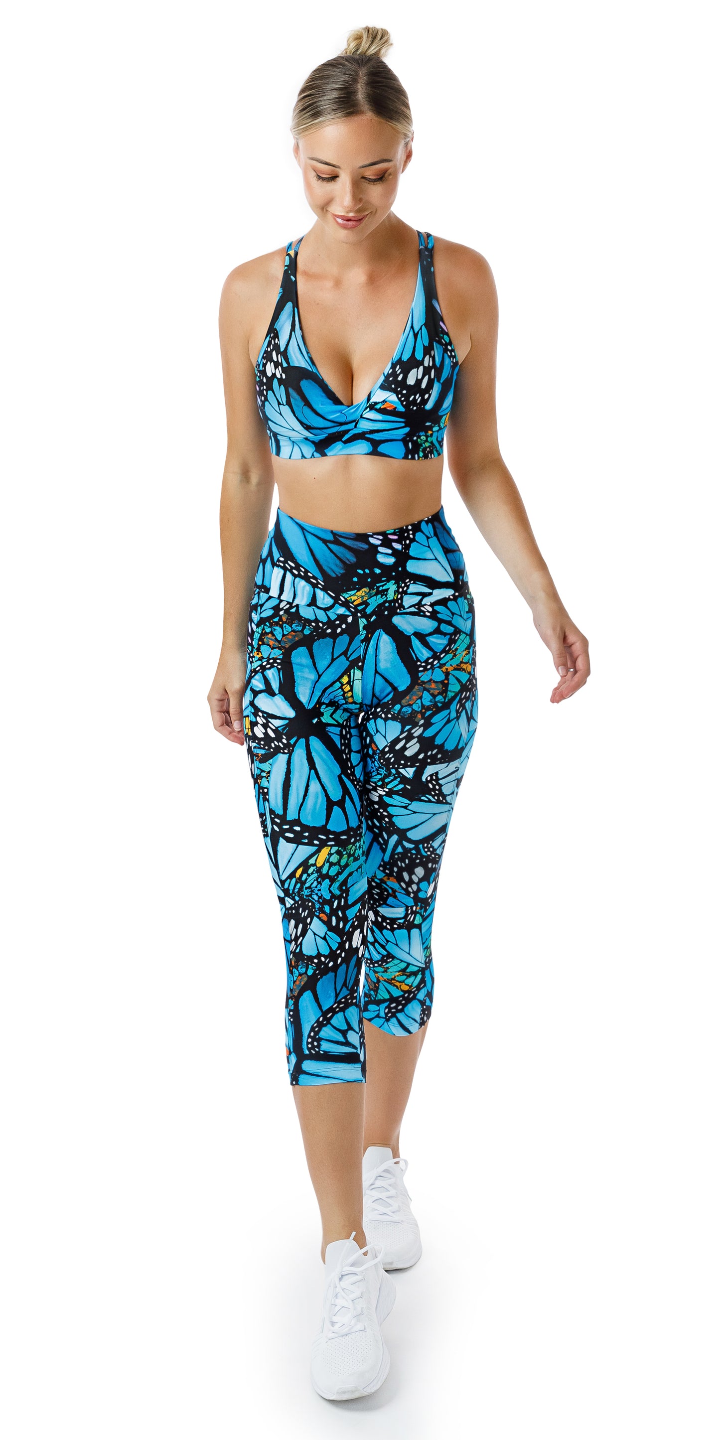 Full body front view of girl in blue animal print JH Butterfly Eco Capri Leggings with Pockets and matching bra walking