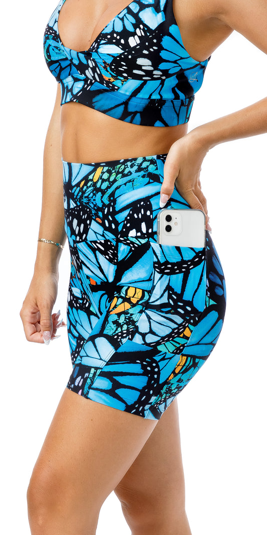 Side view of girl in blue animal print JH Butterfly Midi Shorts with Pockets showing a phone in the pocket