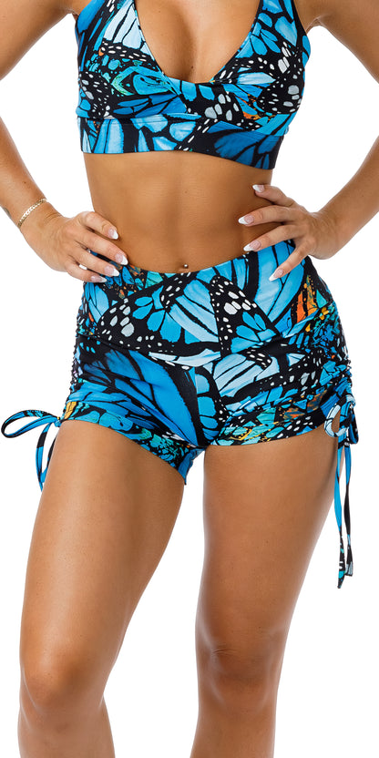 Front view of girl in blue animal print JH Butterfly Eco Bootie Shorts with both hands on waist