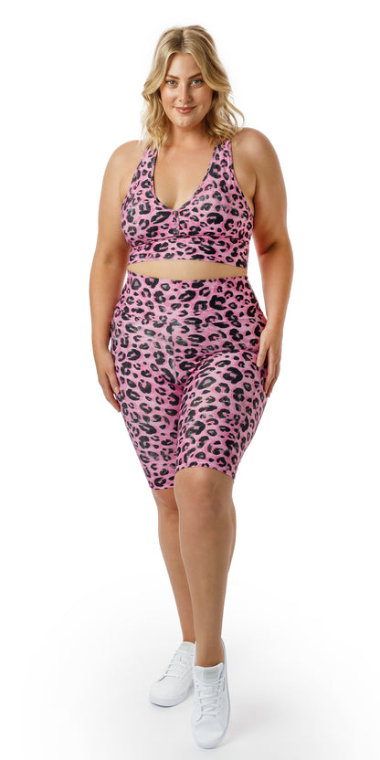 Full body front view of girl wearing pink animal print Candy Leopard Eco Biker Shorts with Pockets and matching sports bra