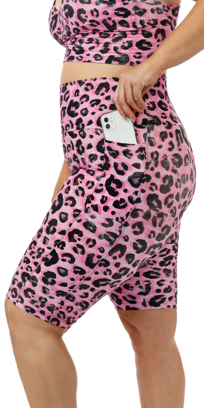 Side view of girl putting phone in pocket of Candy Leopard Eco Biker Shorts