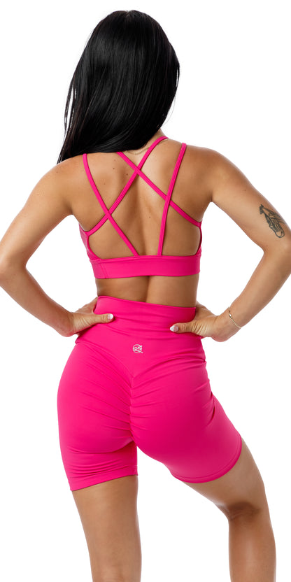 Full body rear view of girl in strappy back bra and pink Candy Body Luxe Scrunch Bum Midi Shorts