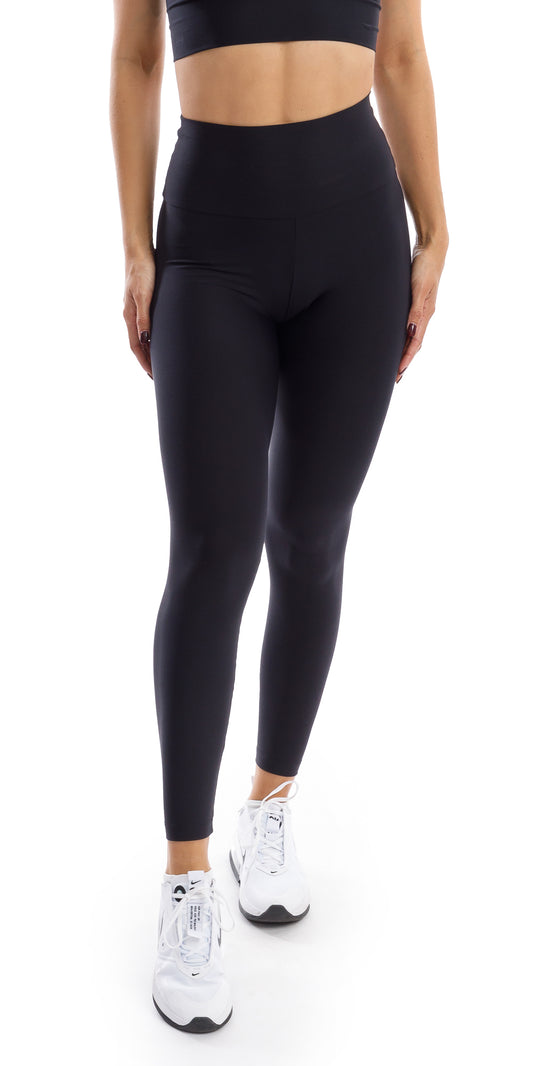 Front view of girl wearing black Midnight Eco Ultra High Waist Leggings putting one leg forward