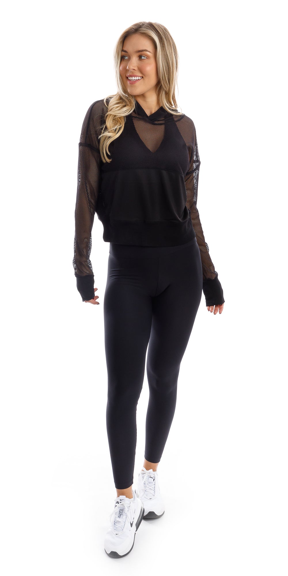 Full body front view of girl in black Midnight Meshed Hoody and black leggings putting one leg forward