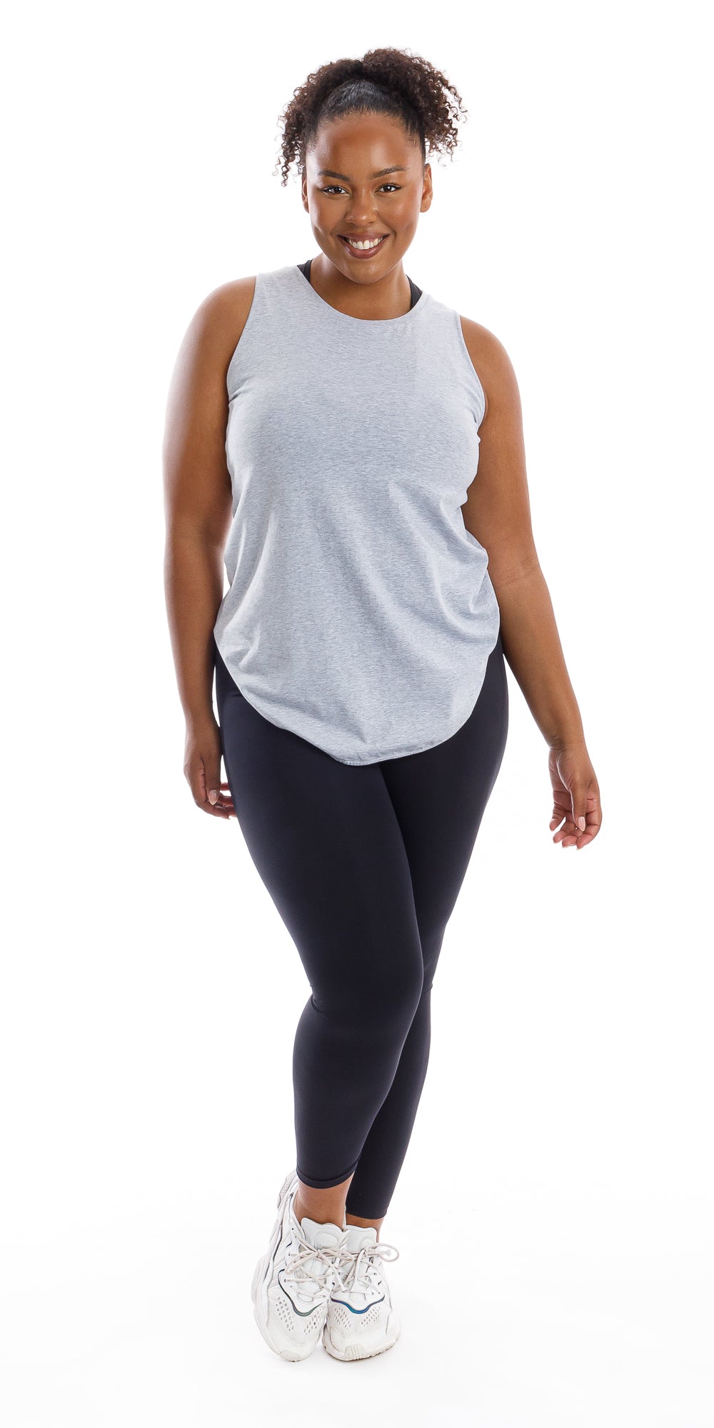 Full body front view of smiling girl in Grey Palm Beach Tank and black leggings