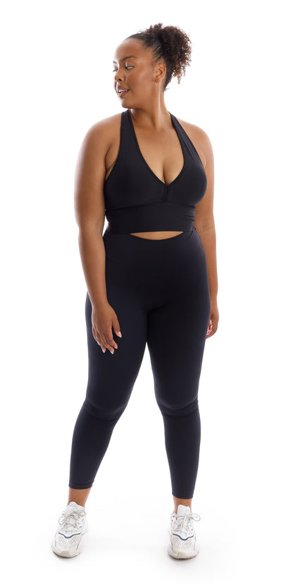 Full body front view of girl in black Midnight Body Luxe Scrunch Bum Leggings and matching bra looking to her right