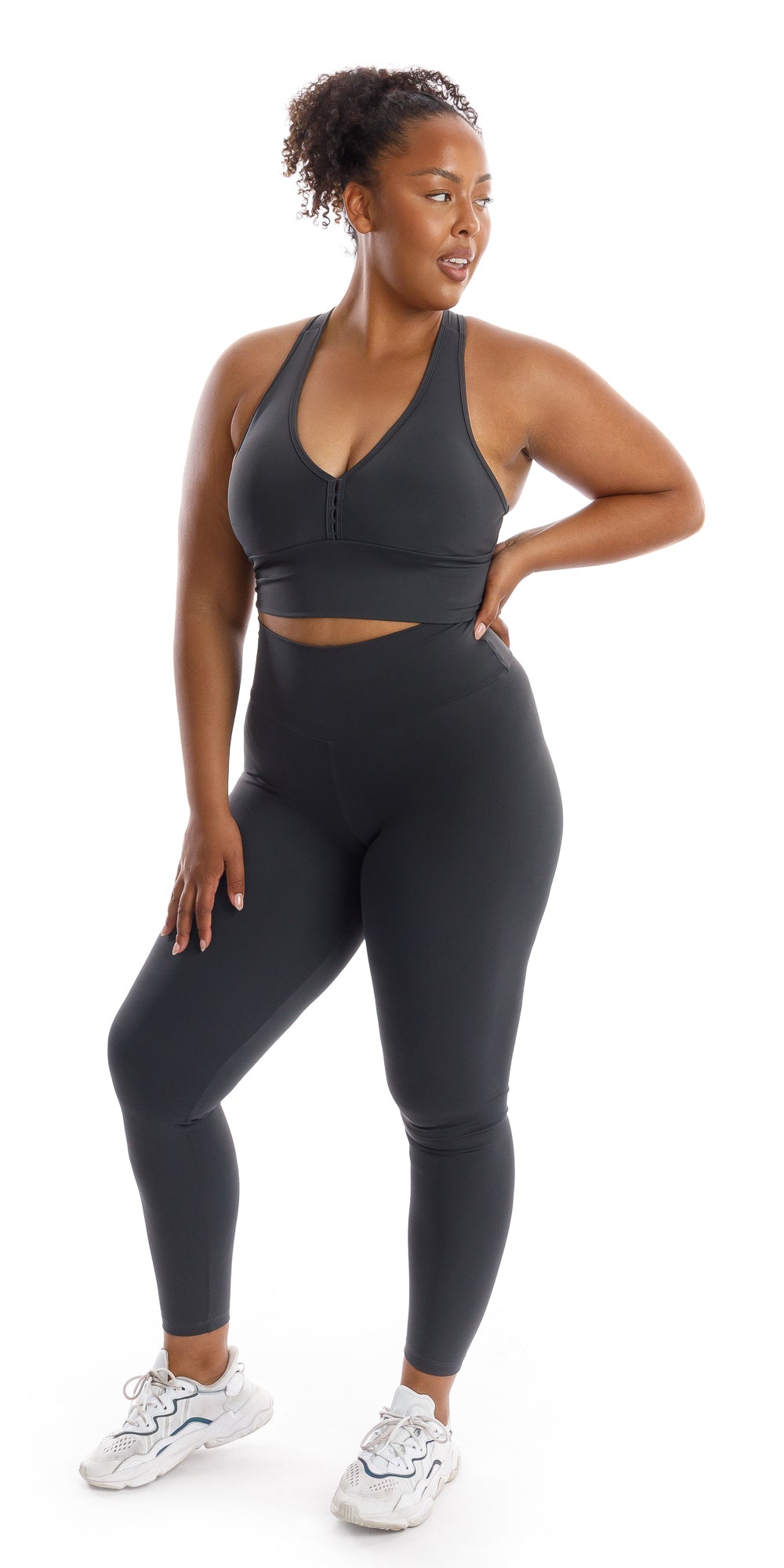 Full body front view of girl wearing grey Liquorice Body Luxe Racer Back Bra and matching leggings putting one hand on waist