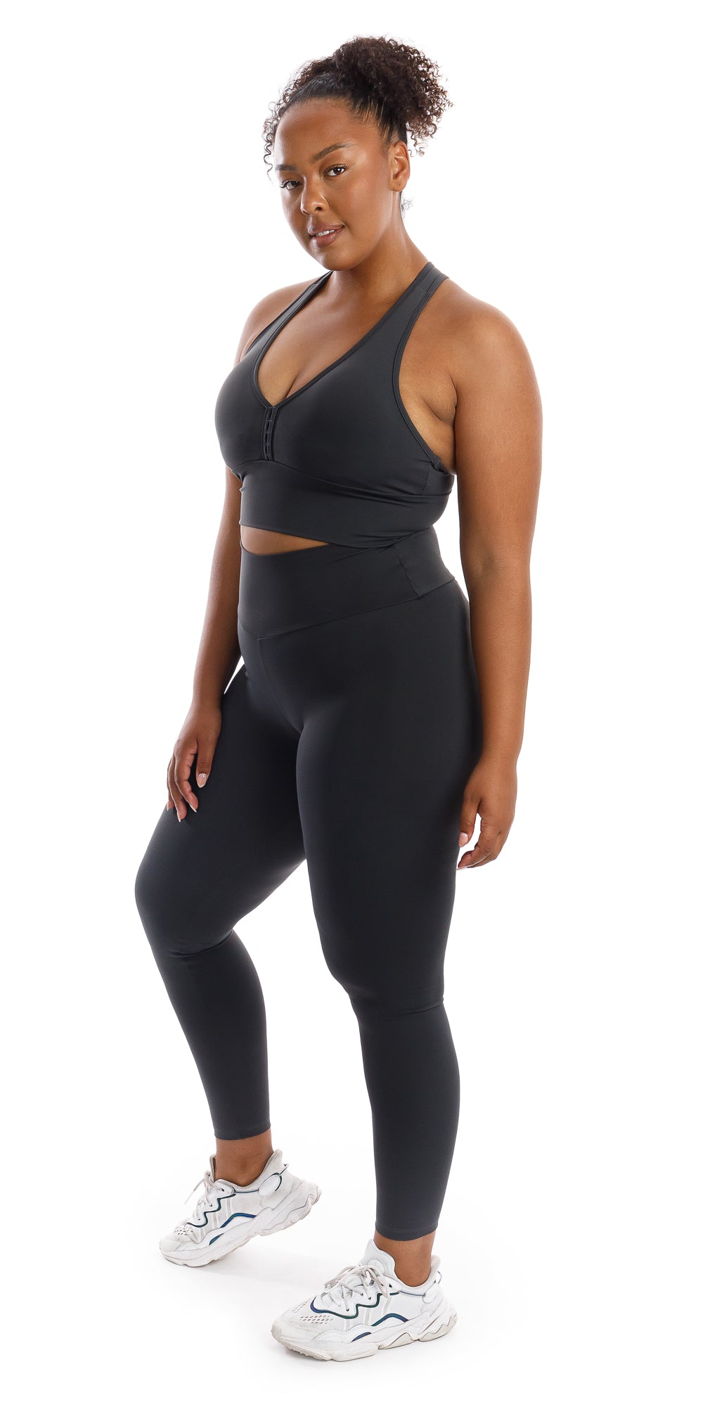 Full body side view of girl wearing grey Liquorice Body Luxe Racer Back Bra and matching leggings