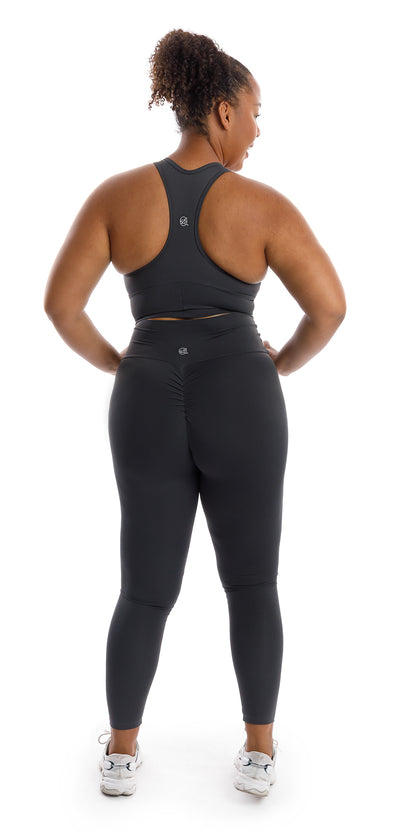 Full body rear view of girl wearing grey Liquorice Body Luxe Racer Back Bra and matching leggings
