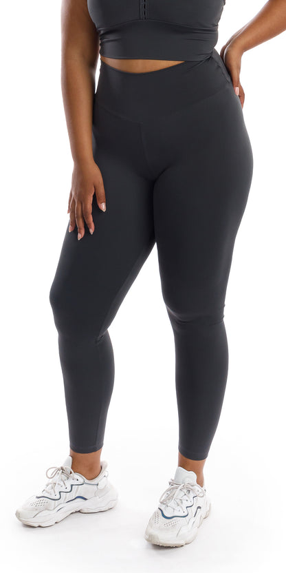 Angled side to rear view of girl wearing grey Liquorice Body Luxe Scrunch Bum Leggings putting one hand on waist