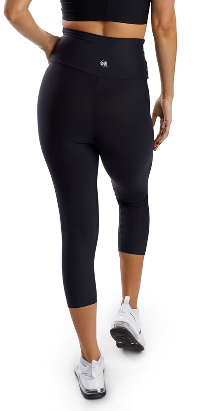 Rear view of girl in black Midnight Eco Capri Leggings putting one hand on waist