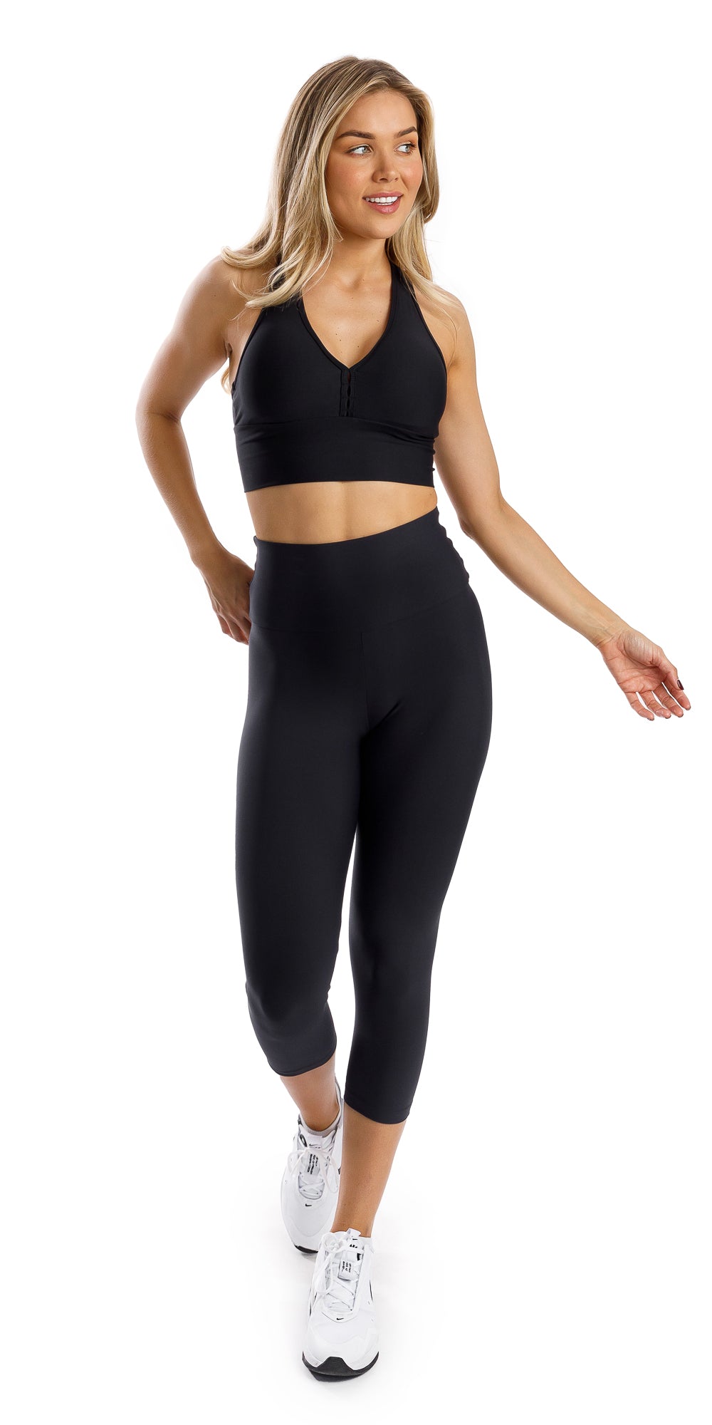 Full body front view of girl in black Midnight Eco Capri Leggings and matching bra walking and swaying arms