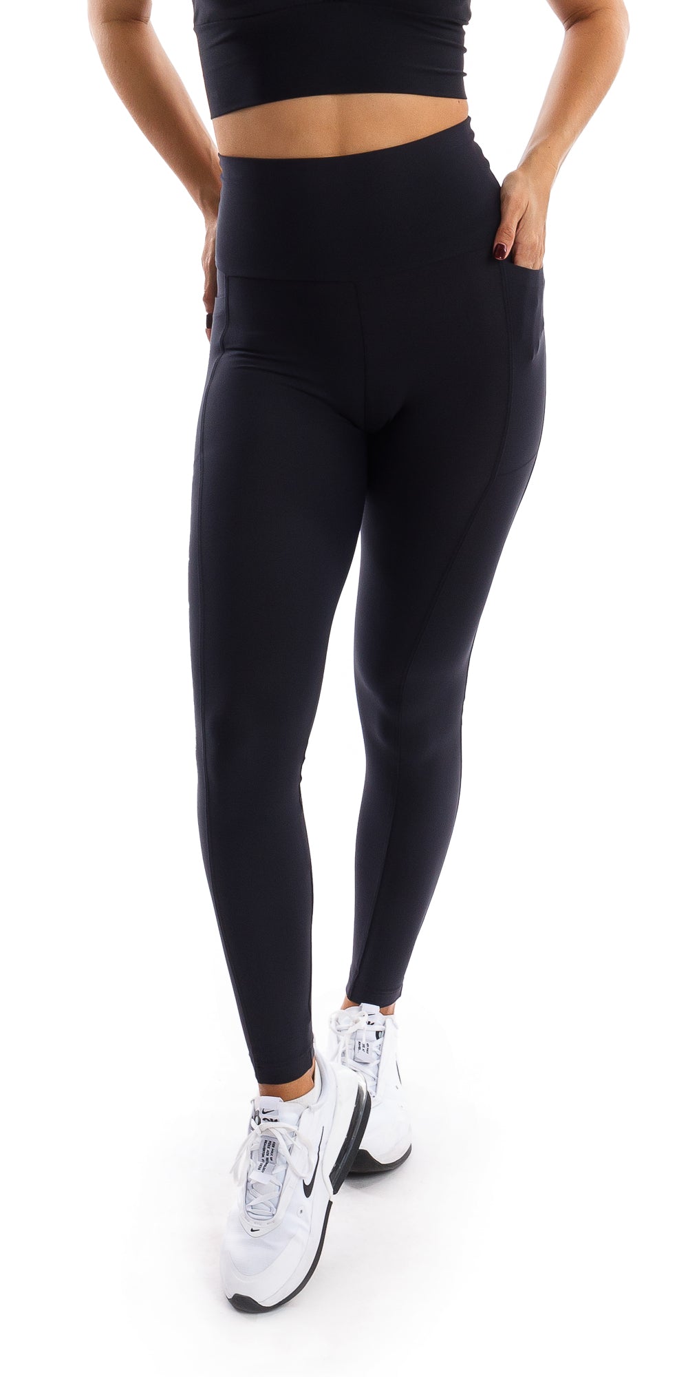 Front view of girl wearing black Midnight Eco Ultra High Waist Leggings with Pockets putting one hand in pocket and one leg forward