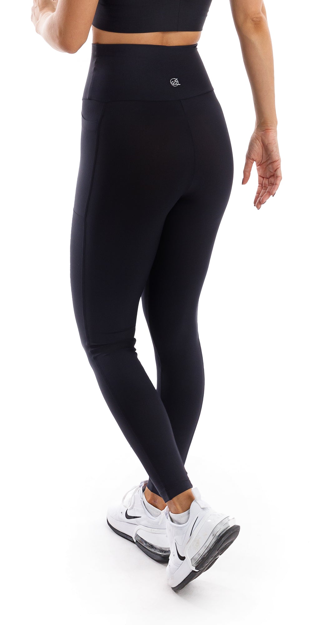 Angled side view of girl wearing black Midnight Eco Ultra High Waist Leggings with Pockets walking