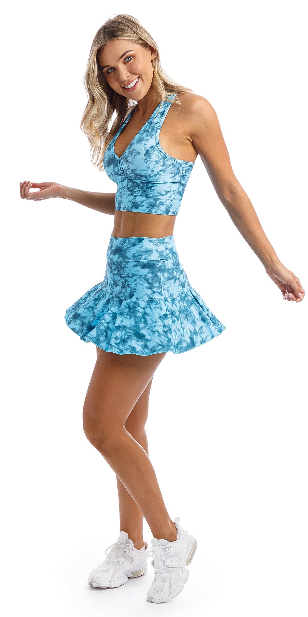 Side view of girl wearing blue tie dye blue crush print skort with pockets & matching racer bra
