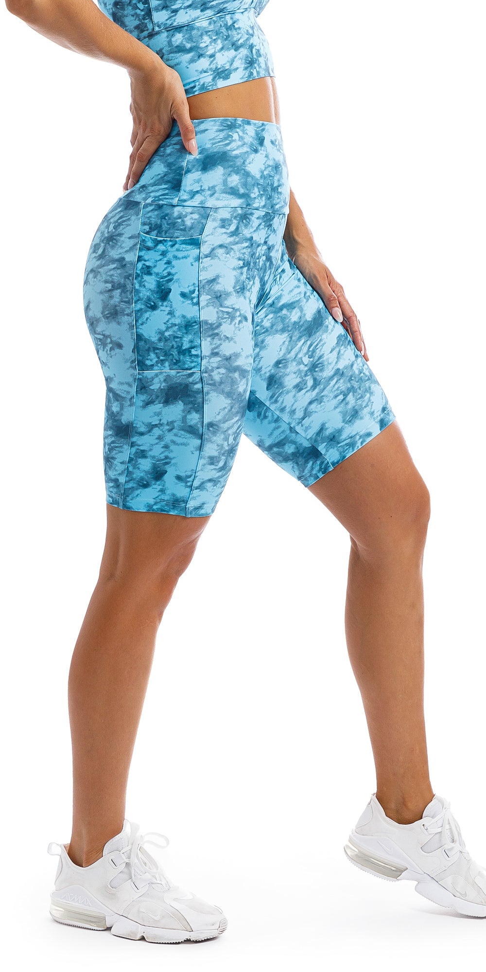 Girl with hand on hip wearing blue tie dye blue crush print high waist Biker shorts with pockets & matching racer back bra