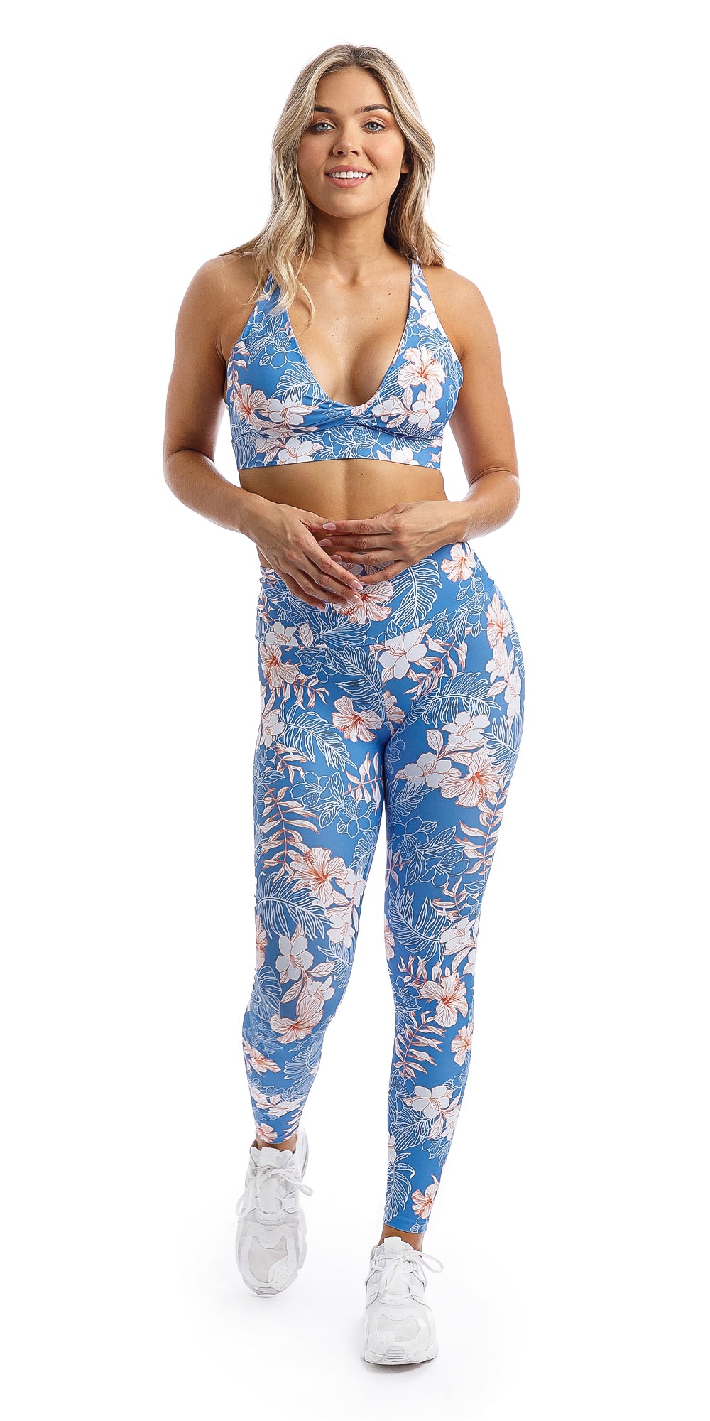 Lady wearing blue, white, pink floral Hibiscus Kiss print ultra high waist leggings & matching infinity bra