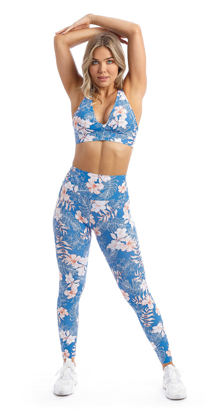 Lady with hands over head wearing blue, white, pink floral Hibiscus Kiss print ultra high waist leggings & matching infinity bra