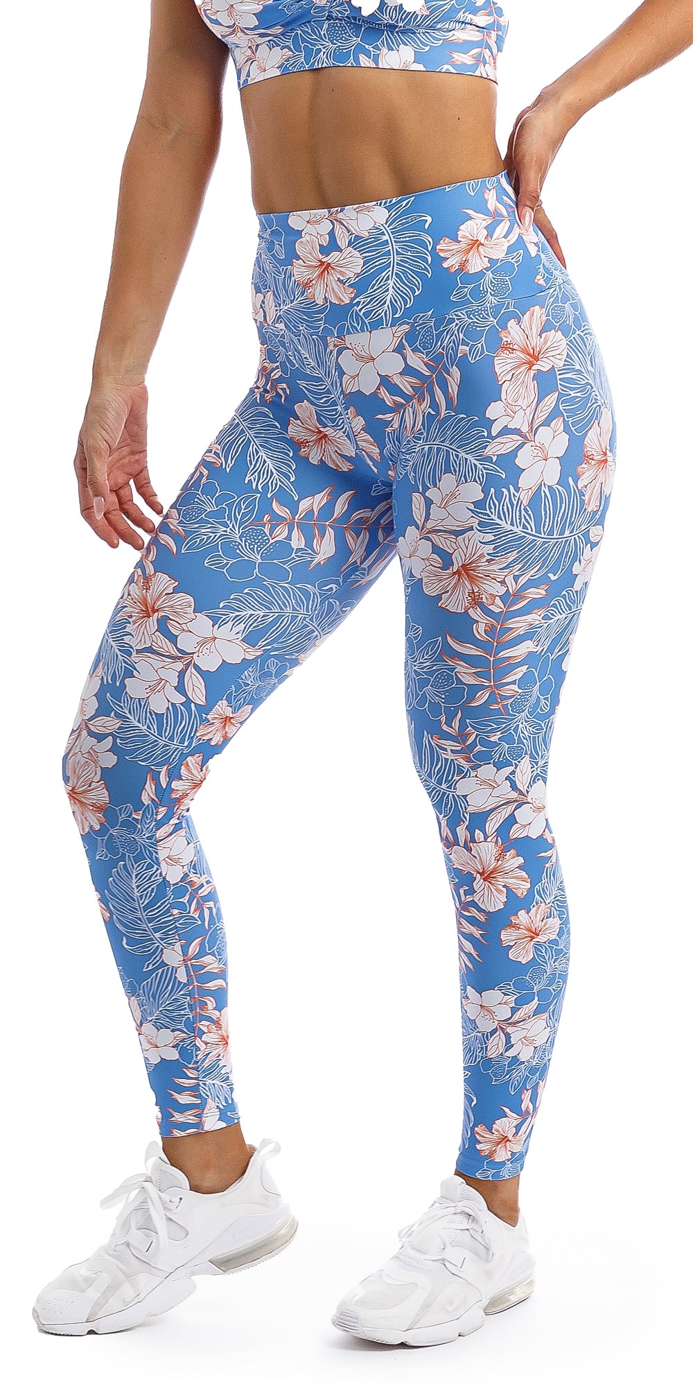 Lady with hand on hip wearing blue, white, pink floral Hibiscus Kiss print ultra high waist leggings & matching infinity bra