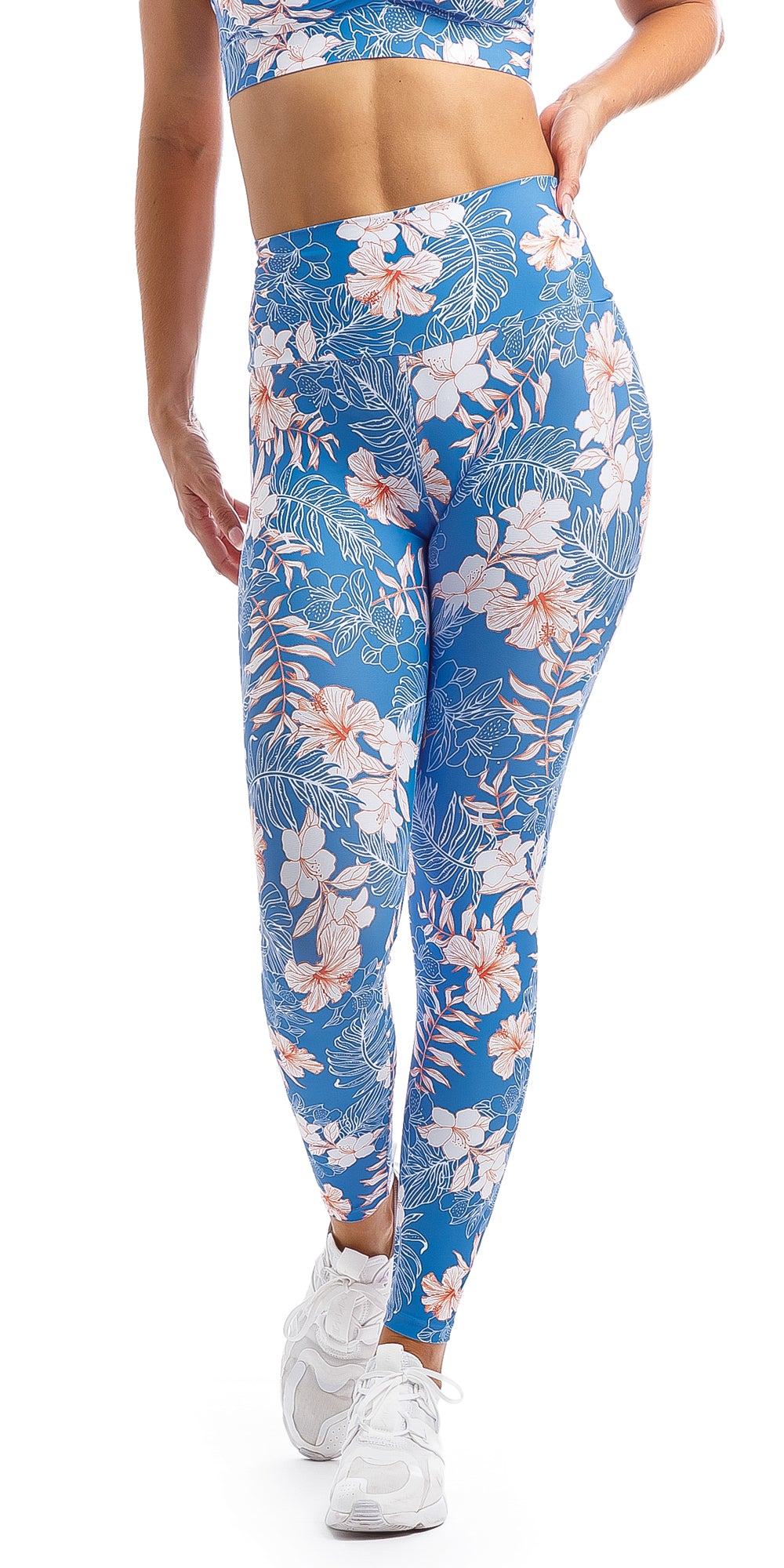 Lady with hand on hip wearing blue, white, pink floral Hibiscus Kiss print ultra high waist leggings & matching infinity bra
