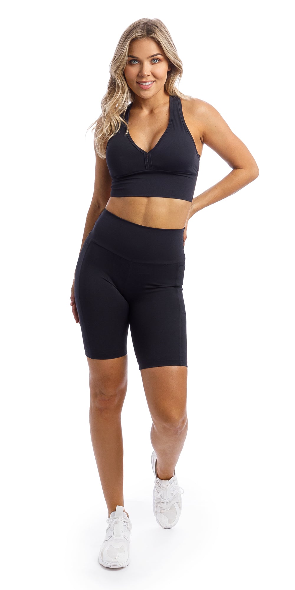 Girl wearing midnight body luxe biker shorts with pockets & matching racer bra