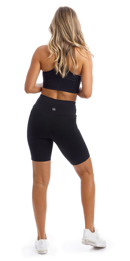Girl wearing midnight body luxe biker shorts with pockets & matching racer bra