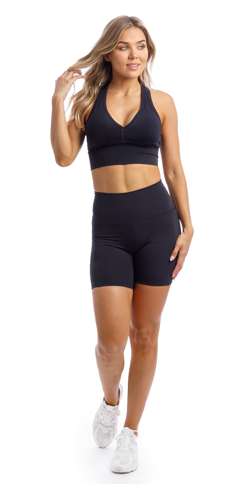 Girl wearing midnight body luxe midi shorts with pockets & matching racer bra