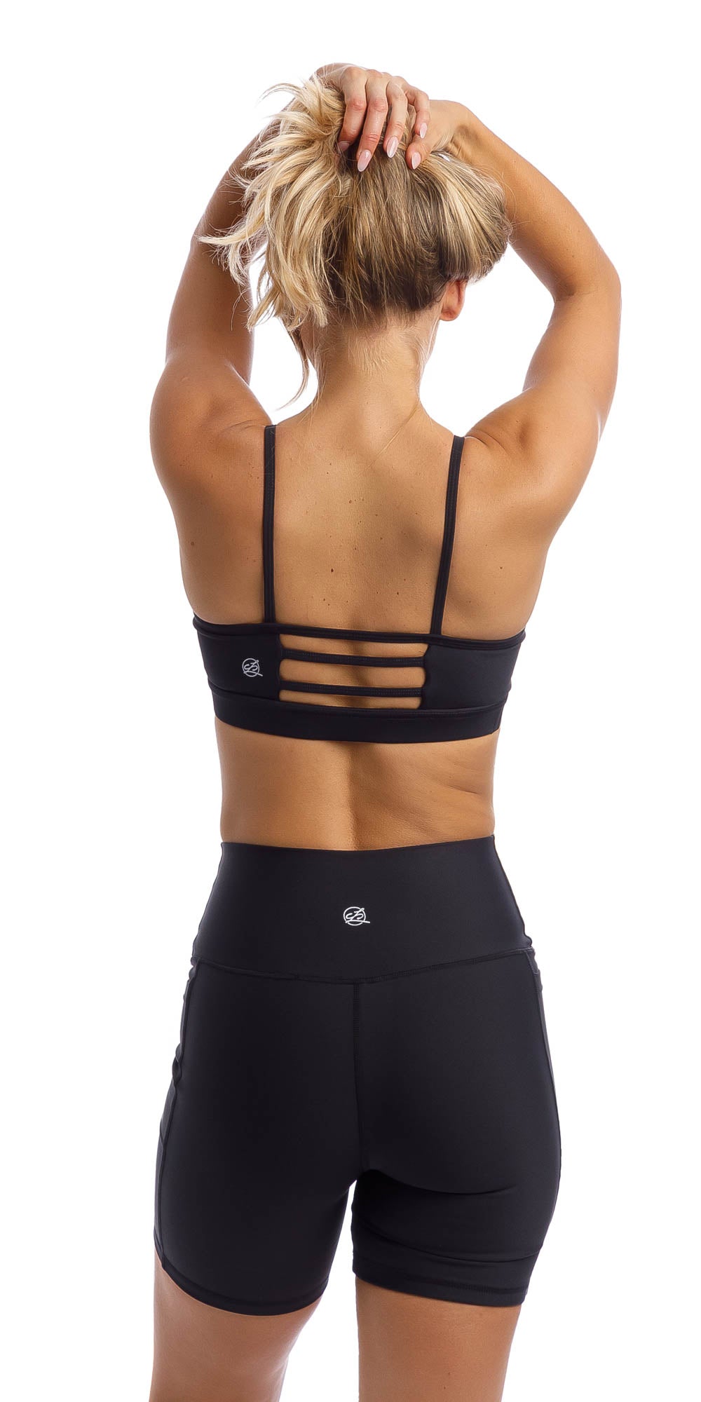 Girl wearing midnight momentum bra with three horizontal back straps & matching lined midi shorts