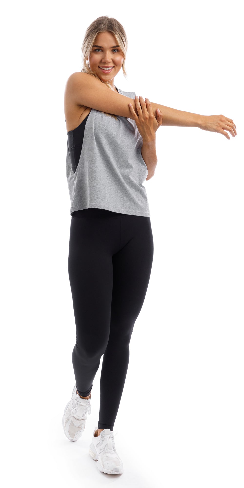 Girl stretching in grey Lennox Tank with open cut out back & ultra high waist midnight leggings