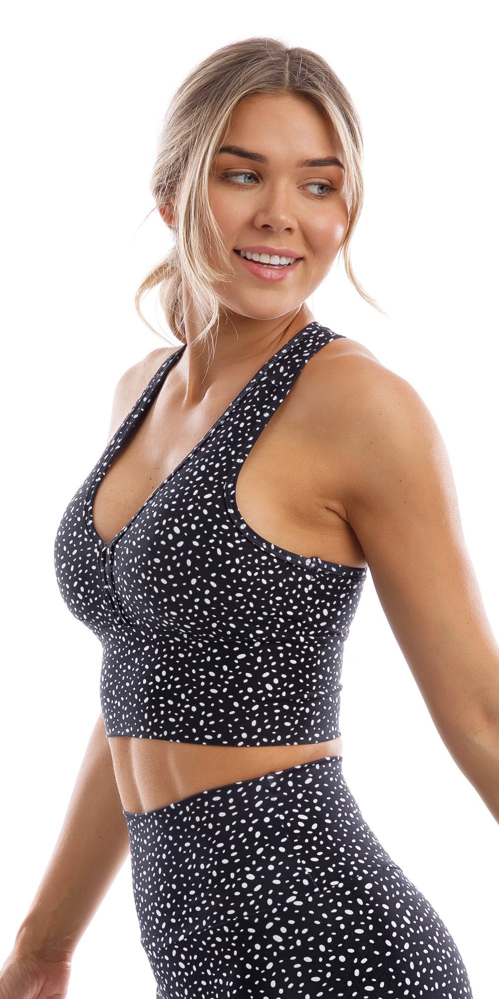 Side view of  girl wearing black Star Dust Body Luxe Racer Back Bra smiling and looking over left shoulder
