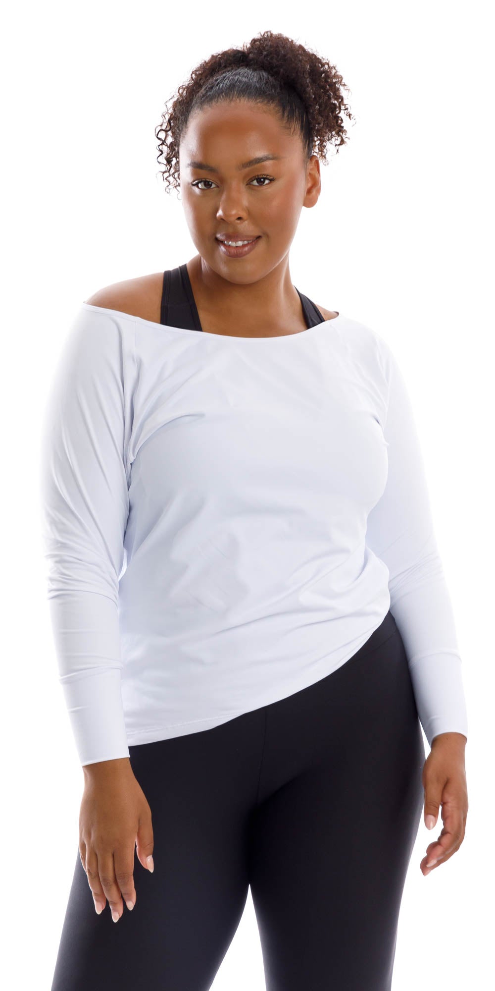 Front view of lady in White Off The Shoulder Long Sleeve Tee and black leggings putting right hand on lap