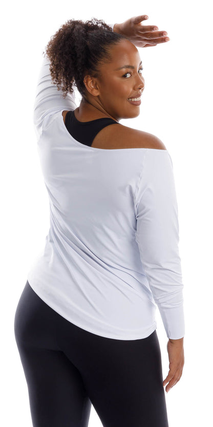 Back view of lady in White Off The Shoulder Long Sleeve Tee and black leggings leaning on hip and putting left hand on forehead while looking back to the camera and smiling