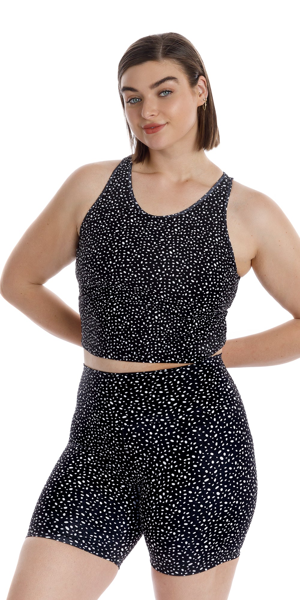 Front view of girl in black Star Dust Crop Top and matching shorts putting both arms behind