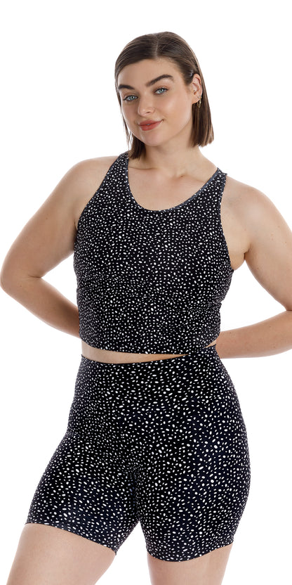 Front view of girl in black Star Dust Crop Top and matching shorts putting both arms behind