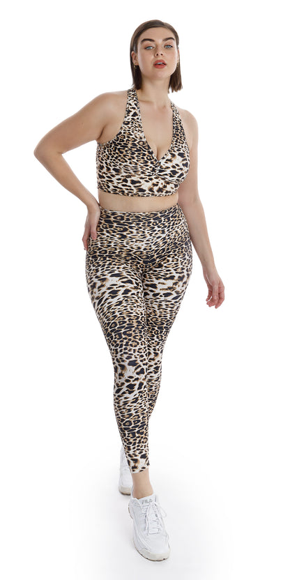 Full body front view of lady in animal print White Cheetah Ultra High Waist Leggings and matching bra putting right foot forward and right hand on waist