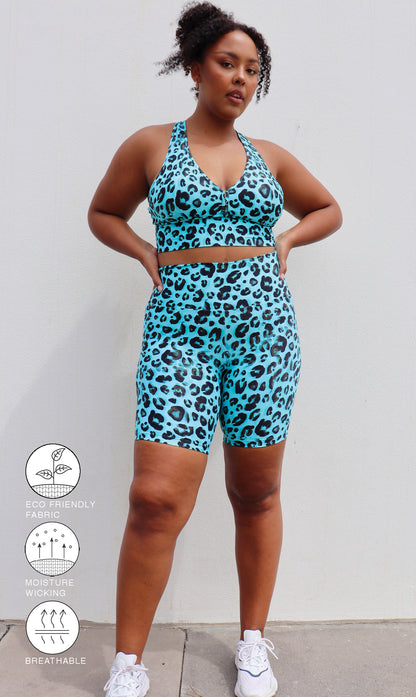 Lady wearing black and aqua leopard print midi shorts with pockets & matching racer back bra