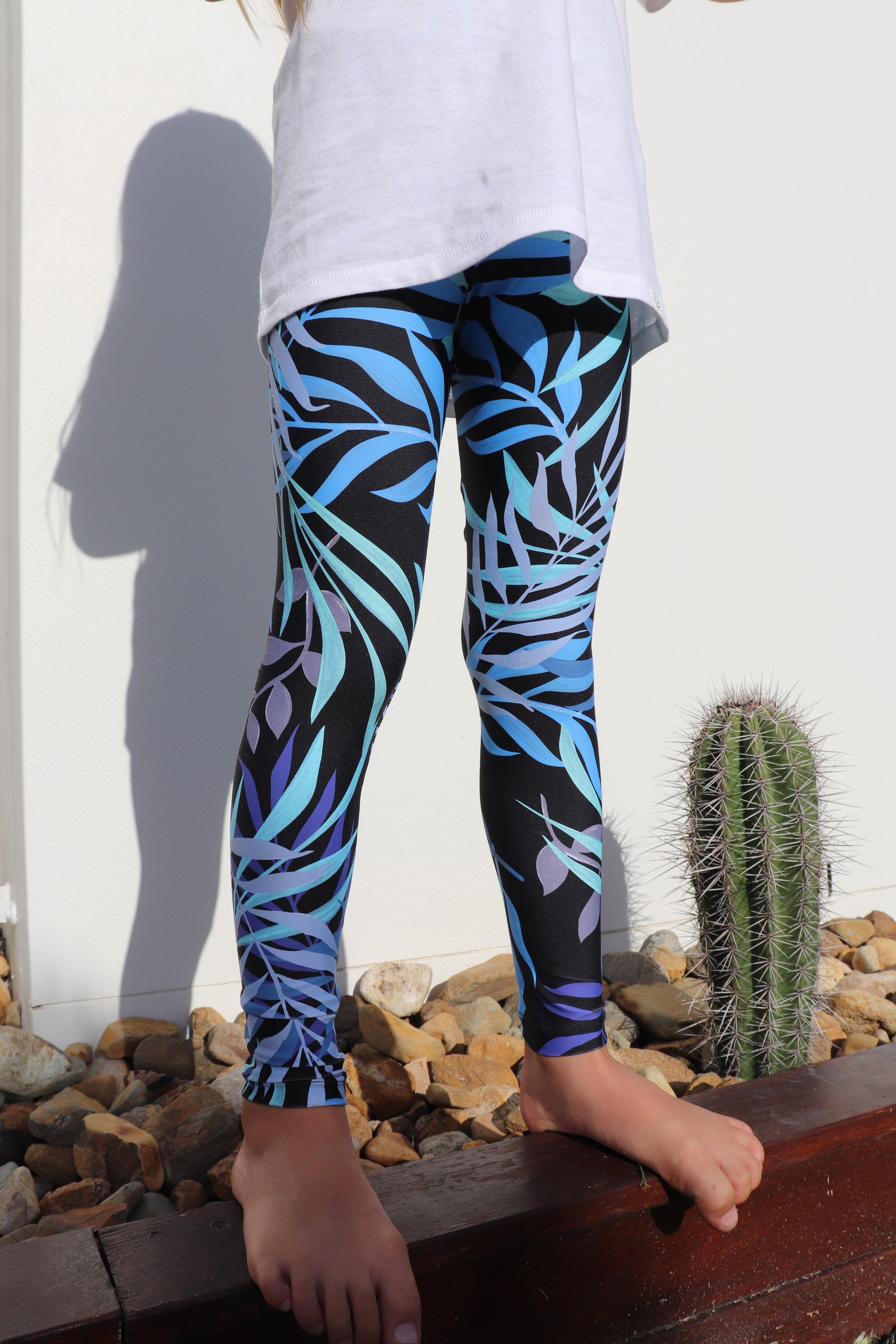 Front view bottom part of girl in printed black Tropical Palm Mini Me Leggings