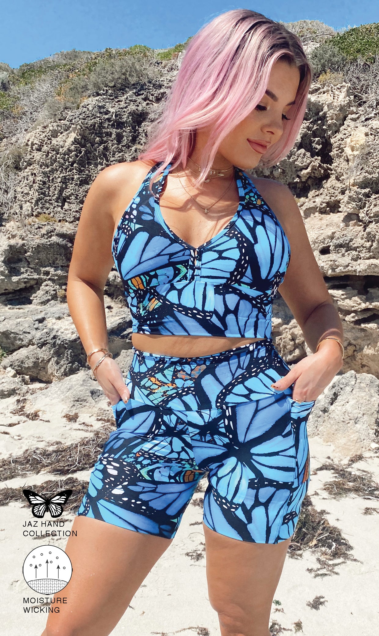 Front view of girl in blue animal print JH Butterfly Midi Shorts with Pockets and matching bra putting both hands in pockets